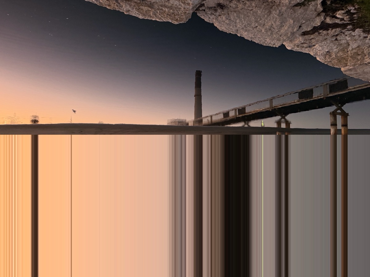 Pixel stretch — cliff and power station at sunset